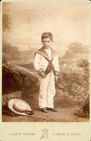 세일러복을 입고 발치에 삼단 짚모자를 쓴 호주 시드니 옥스퍼드 거리의 소년 사진