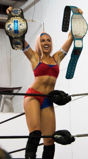 밴 네스가 임팩트 녹아웃 챔피언십과 프로 레슬링 2.0 여성 태그팀 챔피언십을 들고 포즈를 취하고 있다.