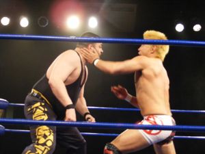 2011년 토자와 (오른쪽)가 에디 킹스턴과 레슬링을 하고 있다.