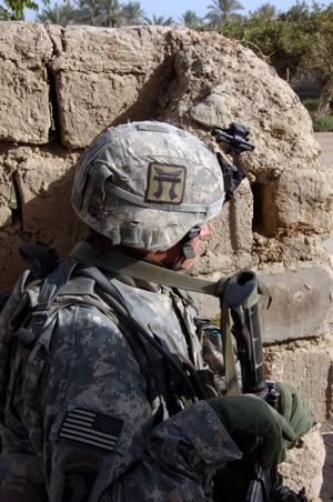 이라크에서 진흙 벽 뒤에 숨어있는 락카산. 그들의 헬멧에는 부대의 독특한 토리이 문양 패치가 있다.