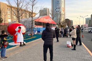 "슈에 롱롱" 인형과 기념 촬영하는 중국 사람들.