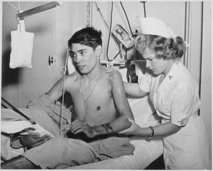 육군 치료사가 군인 환자에게 어깨와 팔꿈치 운동을 시켜 골절 및 탈구 후의 움직임을 증가시키고 있다.