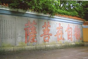 반야심경이 새겨진 (1723년) 관음보살의 도량인 보타산 벽의 모습. 다섯 개의 큰 붉은 글자는 만다린어로 "관자재보살"(guān zì zài pú sà)로, 경전의 시작 부분에 나오는 관세음보살 또는 관음(Guanyin)의 중국어 이름 중 하나이다. 나머지 경전은 검은 글자이다.