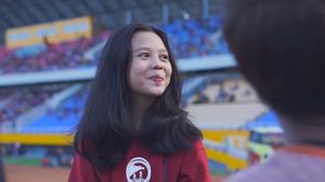 스리위자야를 응원하며 짙은 적갈색 의상을 입은 소녀.