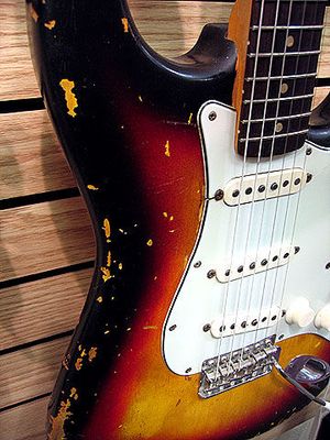 1963 Stratocaster with alder body, rosewood finger board, three-ply pickguard and three-color sunbirth finish. The nitrocellulose lacquer shows characteristic chipping from use.
