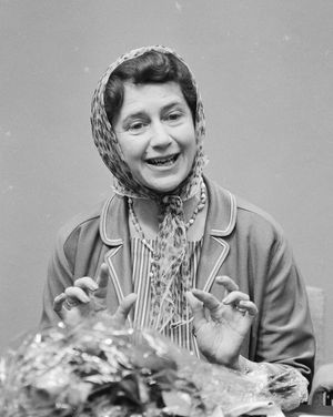 머리 스카프를 쓰고 카메라를 향해 미소짓는 젊은 여성