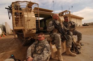 2007년 3월, 미 육군 병사들이 이라크 포워드 작전 기지 칼수에서 정찰 임무를 위해 대기하며 M113의 후면 램프에 앉아 있다.