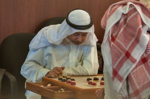 두 명의 카타르인이 전통 보드 게임인 다마를 하고 있다.