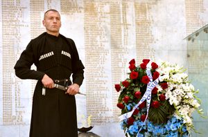 조지아 병사가 트빌리시 영웅 광장의 기념비에서 초하를 입고 서 있다