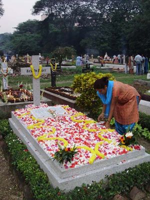인도의 한 기독교 여성이 꽃잎으로 무덤을 장식하고 있다.