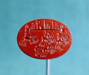 재스퍼 인타글리오 (2세기 AD)는 전차 경주를 묘사하며, 분리 장벽의 양쪽 끝에 있는 세 개의 뾰족한 metae가 상단에 표시되어 있다 (월터스 미술관)