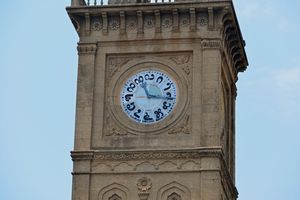 칸나다 숫자가 있는 마이소르의 시계. 숫자 3(왼쪽), 6(아래쪽), 9(오른쪽) 및 12(위쪽)는 똑바로 서 있고, 숫자 1, 2, 4, 7 및 8은 오른쪽으로 약간 회전되어 있으며, 숫자 5, 10 및 11은 왼쪽으로 약간 회전되어 있으므로 모두 똑바로 서 있는 것처럼 읽을 수 있다(숫자 10, 11 및 12는 약간의 회전을 무시하고 왼쪽에서 오른쪽으로 정상적으로 읽음).