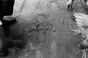 1968년 전라남도에서의 고누 놀이 장면. 흙바닥에 선을 그어 말판을 만들고 돌멩이와 나뭇가지를 말로 사용하였다.