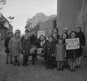 1962년 카나번의 아이들이 가이 포크스 허수아비와 함께 서 있다. 표지판에는 웨일스어로 "가이에게 1페니"라고 적혀 있다.