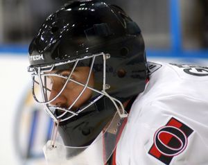 검은 골텐더 마스크와 하키 장비를 착용한 남자