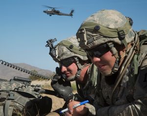 미 육군 병사들이 근접 항공 지원을 조율하고 있다. 배경에는 앞서 언급한 근접 항공 지원, AH-64E 아파치 가디언 공격 헬리콥터가 있다.