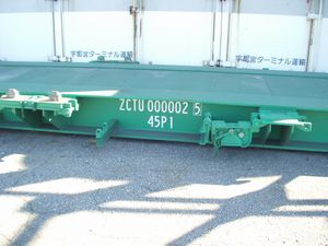 중앙의 흰색 등록 번호 표시 오른쪽은 JR 화물 전용 조임 장치가 반 회전하여 아래로 향하여 장치의 돌출부를 없애 플랫 상태가 되어 있다. 마찬가지로 표시 왼쪽은 국제 규격으로 채택된 12 ft형 컨테이너 하부의 네 모퉁이를 고정하는 트위스트 록용 갈고리가 항상 돌출된 상태로 세팅되어 있다. 앞서 언급한 JR 화물용 12 ft 컨테이너를 적재한 경우에는 접촉하지 않도록 각 트위스트 록 위치에 따라 좌우 어느 한쪽 측면으로 반 회전하여 바닥이 플랫 상태가 된다.