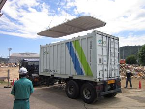 히로시마현 미하라시 내 (2018년 7월 호우) 관련 재해 쓰레기 적재 후, 비산 방지를 위해 컨테이너 지붕 덮개를 크레인으로 닫기 직전 (타입 코드 22U6)