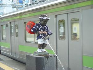 일본 도쿄 하마마쓰초역 플랫폼에 있는 오줌싸개 소년 복제품. 역무원이나 자원봉사자들이 계절별로 의상을 갈아입힌다.