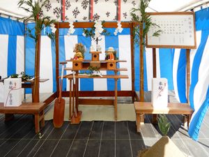 지진제의 제단. 오른쪽 상단의 간판에는 「지진제 순서/1 신사/수발(일동 기립)/강신의 의(일동 기립)/헌찬/축사 주상(일동 기립)/절마 산미/괭이질 의/옥구 봉전/철찬/승신의 의(일동 기립)/1 신주 배대/신관 퇴하」라고 적혀 있다. 앞쪽 오른쪽 아래에는 모래가 쌓여 있다. 도쿄도 나카노구에서 촬영.