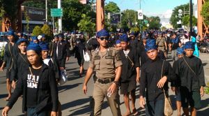 파란 머리 장식을 한 젊은이들이 도시 거리를 걷고 있다