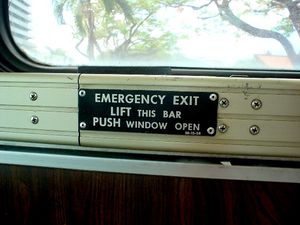 스쿨 버스 창문에 설치된 비상구 작동 안내 금속판.