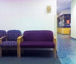 An extra wide chair beside a number of normal sized chairs.