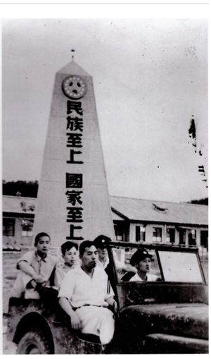 수원에 위치한 조선민족청년단 중앙훈련소. "인종주의, 최고 민족주의"라는 슬로건이 적힌 탑을 배경으로 지프차를 탄 다섯 사람의 모습이 담겨 있다.