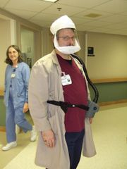 HEPA 필터가 장착된 전동식 공기 정화 호흡기 (PAPR)를 착용한 병원 직원이 결핵과 같은 공기 중 또는 에어로졸 병원체로부터 보호하는 데 사용하고 있다.