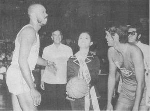 PBA의 미스, 미아 몬테마요르가 1975년 4월 9일 필리핀 농구 협회 개막식에서 마리와사의 시스코 올리버와 콘셉시온의 라몬 루신도 사이에서 시구하고 있다. PBA 커미셔너 레오 프리토와 PBA 회장 에머슨 코세텡이 지켜보고 있다.