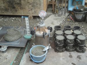 레미콘 시험 등의 모습. 왼쪽은 슬럼프 및 슬럼프 플로우 측정. 중앙은 공기량 측정, 그 아래는 레미콘의 온도 측정. 오른쪽은 굳은 후의 강도 시험에 사용되는 샘플.