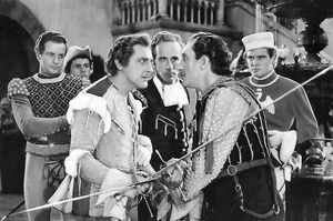 르네상스 복장의 6인 단체 사진; 세 명의 중심 인물이 검을 함께 잡고 있음, 삼총사 스타일