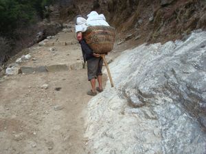 토쿠마라고 불리는 T자형 지팡이를 도코라고 불리는 짊어지는 짐받이 아래에 넣고, 짐을 운반하는 짐꾼이 휴식을 취하는 모습