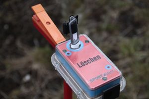 전자 펀처가 있는 SportIdent 스테이션 (펀처는 일반적으로 손가락에 착용합니다)에 백업 바늘 펀처가 부착되어 있습니다