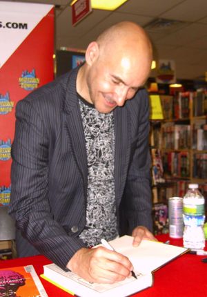 2011년 7월 19일 맨해튼 미드타운 코믹스에서 슈퍼히어로 분석서 슈퍼갓(Supergods)에 서명하는 모리슨