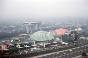 안개 낀 항공 뷰로, 대형 건물, 주요 도로, 헬기 착륙장, 두 개의 컬러 돔이 보입니다.
