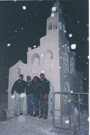 멕시코 조각가 아벨 라미레즈 아길라르가 1999년 국제 눈 조각 챔피언십에서 다른 팀원 그라시엘라 페레이로, 가브리엘 라야르, 로버트 핸콕과 함께 눈 조각 "리틀 빌리지" 앞에서 포즈를 취하고 있다.