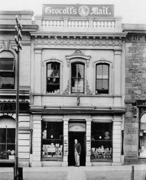 그로콧츠 메일(Grocott's Mail)<i>의 창립자이자 초대 소유주인 토마스 헨리 그로콧(Thomas Henry Grocott, 1838-1912)이 그로콧츠 메일 신문사 앞에 서 있다.