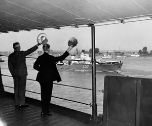 1945년 7월 15일, USS Augusta호에 탑승한 미국 대통령 해리 S. 트루먼과 국무장관 제임스 F. 번스가 포츠담 회담으로 향하면서 HMS Hambledon호에 손을 흔드는 모습