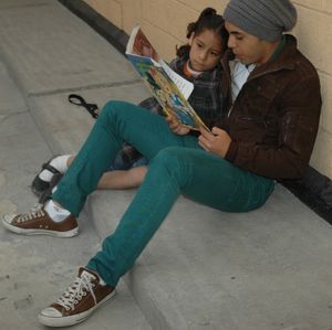 봉사자가 멕시코 시티의 Casa Hogar de las Niñas에서 한 소녀에게 책을 읽어주고 있다.