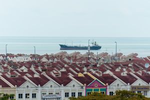 매립지 위에 건설된 현대식 상업 시설에서 멀리 떨어진 말라카 해협에 정박한 배.