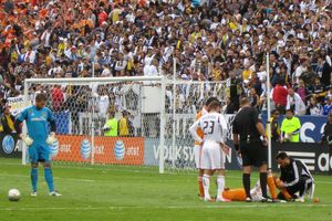 칼렌 카가 2012 MLS컵 경기 중 부상을 입고 쓰러져 있고, 데이비드 베컴이 지켜보고 있다.