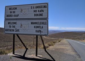 R354를 따라 웨스턴케이프주에서 노던케이프주로 들어오는 운전자들을 환영하는 표지판. 표지판은 아프리칸스어 (왼쪽 상단), 영어 (왼쪽 하단), 츠와나어 (오른쪽 상단) 및 코사어 (오른쪽 하단)로 표기되어 있다.