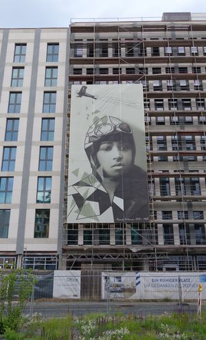 프랑크푸르트 공항의 "Bessie-Coleman-Straße"(일명 "Bessie-Coleman-street")의 Gateway Gardens 지구에 있는 비계에 걸린 대형 포스터