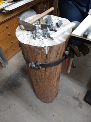 모자이크 타일을 자르기 위한 망치와 정반이 있는 나무 블록