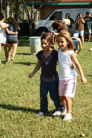 두 아이가 발목에 묶인 끈으로 나란히 서 있다.