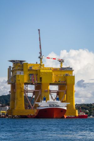 노르웨이에서 해상 풍력 발전 단지를 위한 HVDC 변환소를 수용하는 해상 구조물이 중량물 운반선에 의해 이동되고 있다.