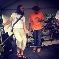 대중음악 그룹의 타악기 연주자가 크고 낮은 음의 베이스 트라이앵글을 연주하고 있다.