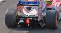 the rear of a Formula One car with a double decker diffuser located between the rear wheels