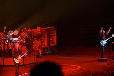 러쉬의 라이브 공연, 배경에 회전구이 기계와 요리사가 있다.